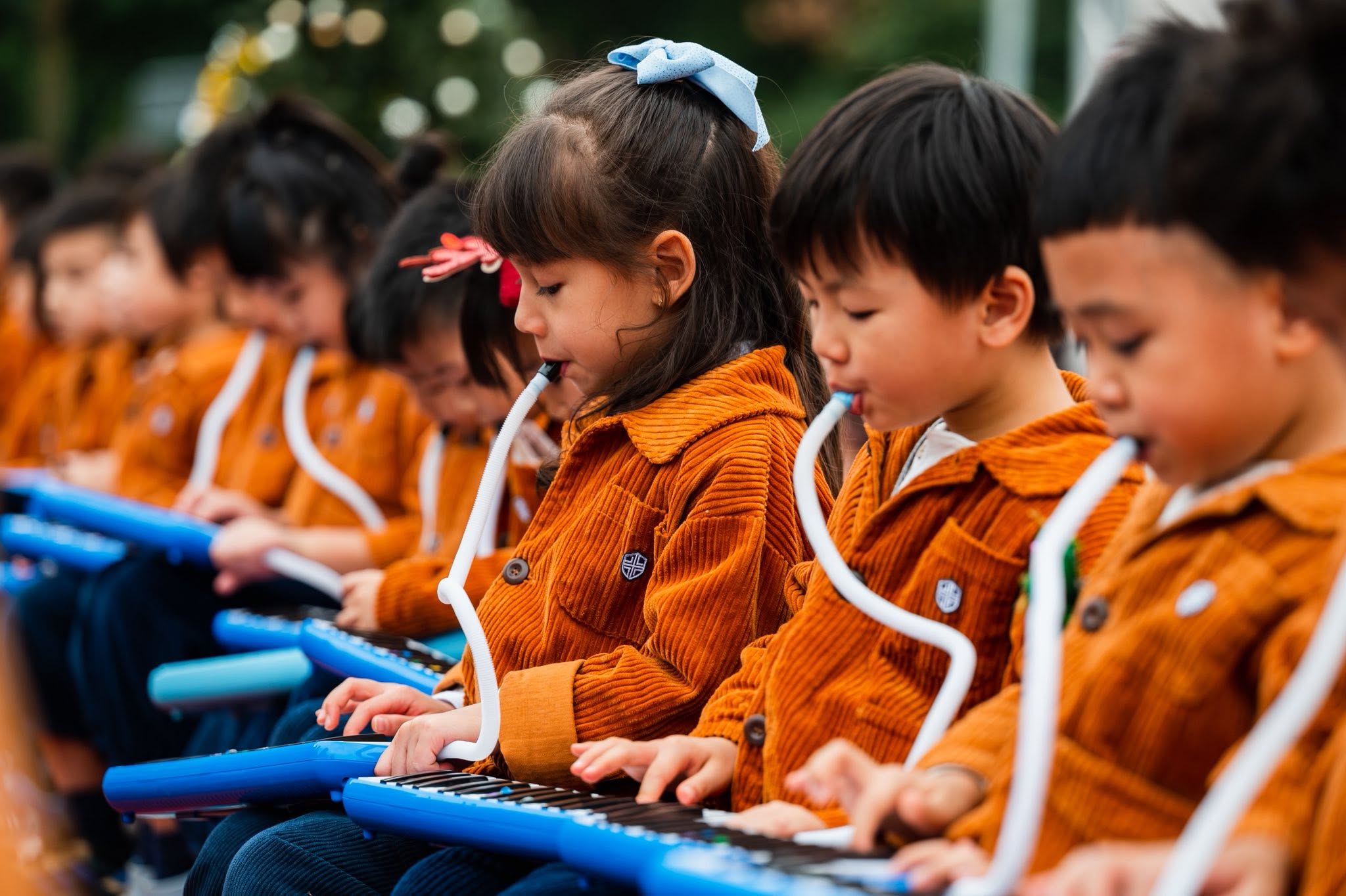 孩子們在校慶舞台上合奏口風琴