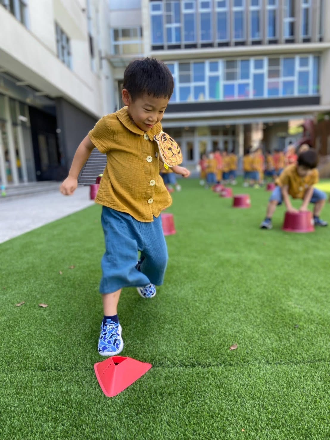 孩子在草地上沿著標記點練習跳躍