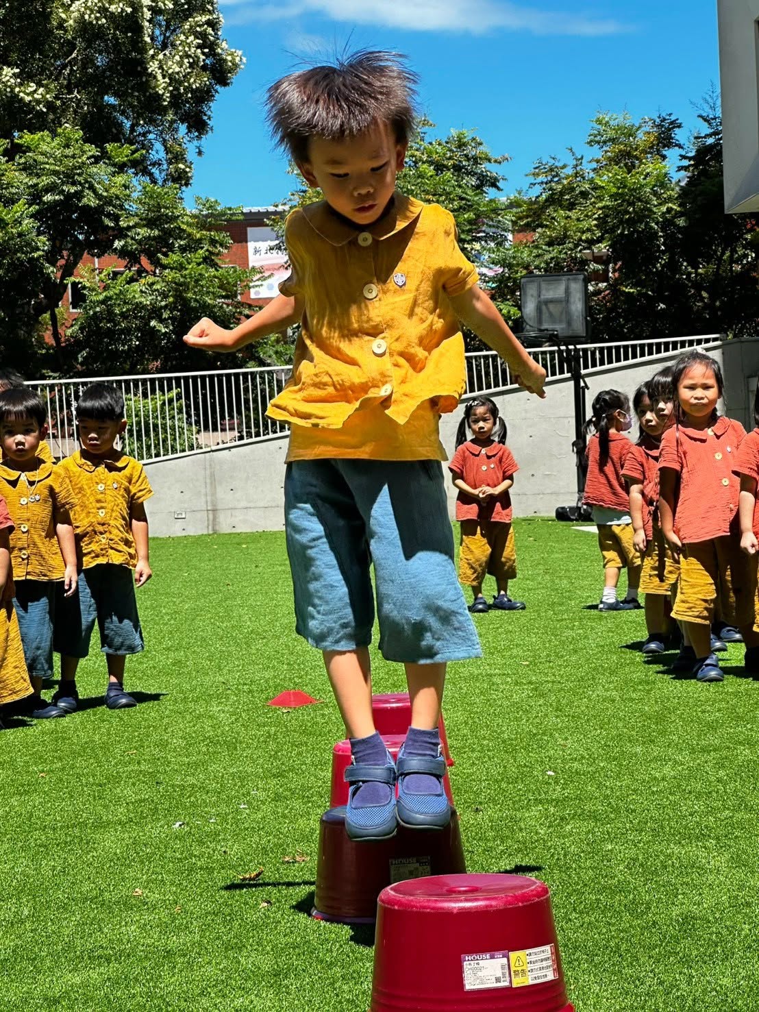 孩子練習踩著踏桶前進，培養平衡感