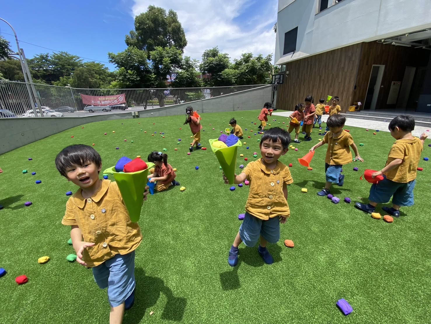 孩子們在草地上用三角錐收集沙包